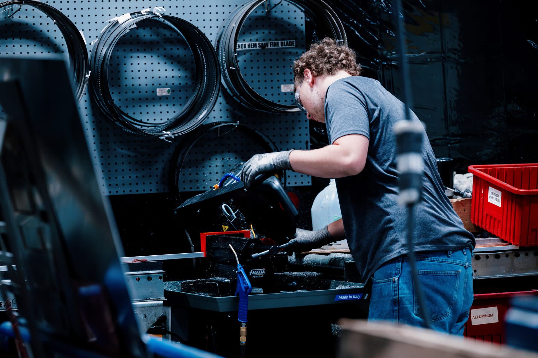 A team member working at a bench beside coiled tubing racked on the shop wall