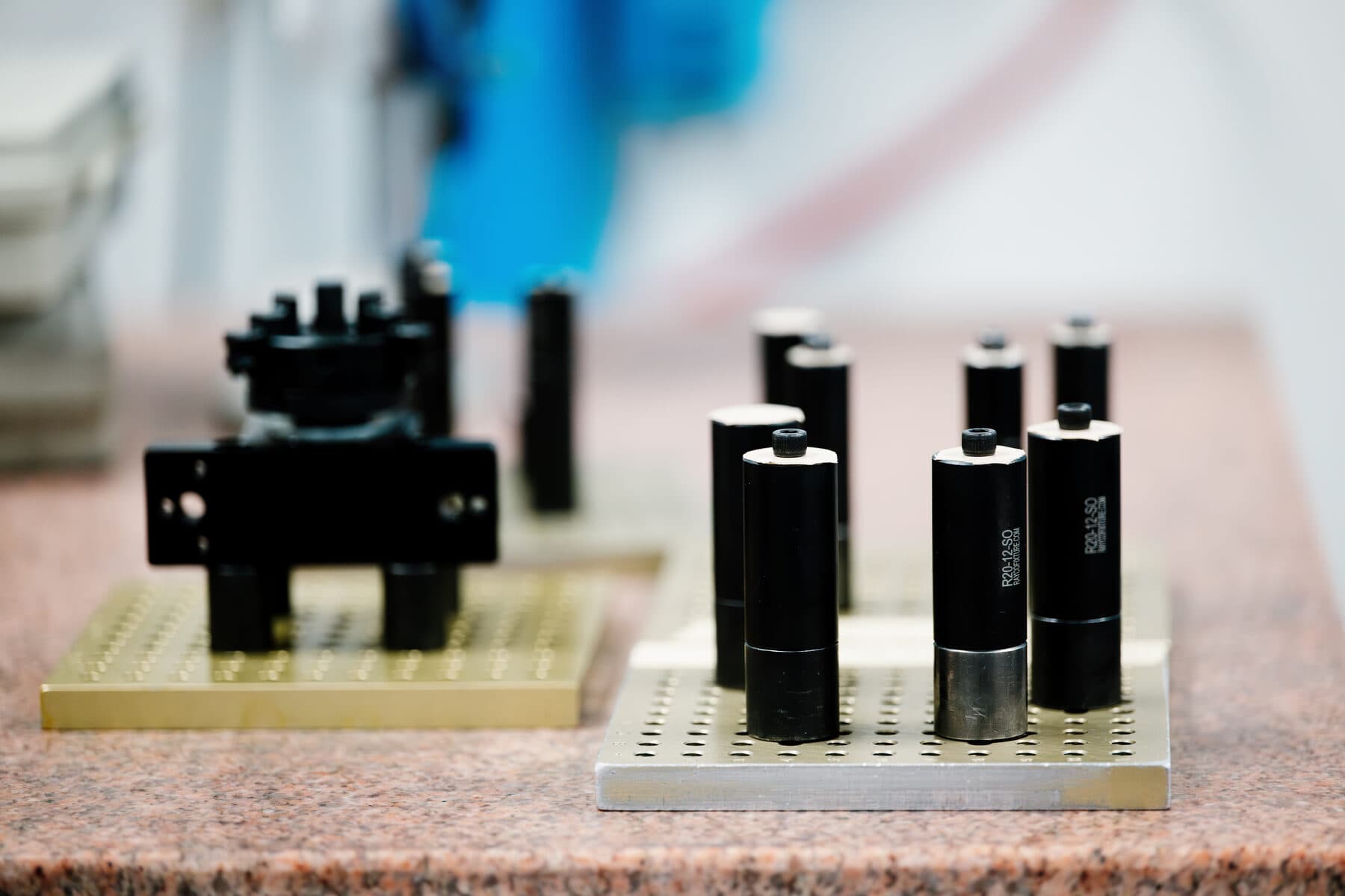 Machined cylindrical parts set on gauge plates on a granite inspection table