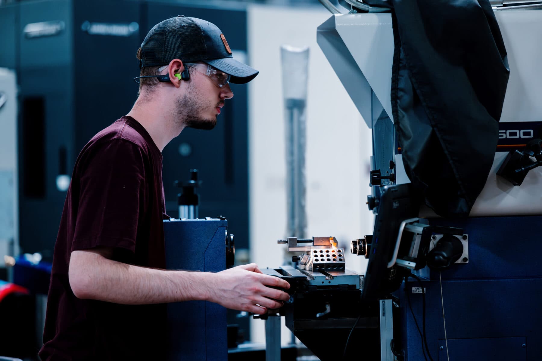 A machinist at the controls of a CNC machine