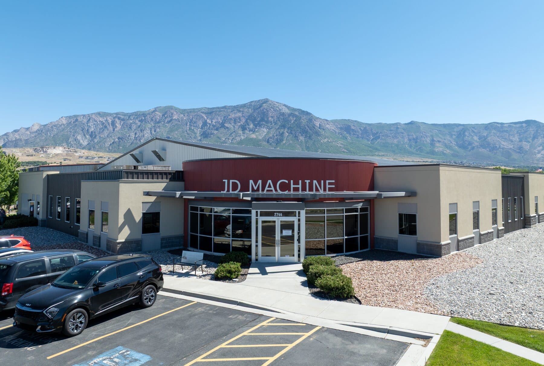 The JD Machine building in Ogden, Utah, with the mountains behind it