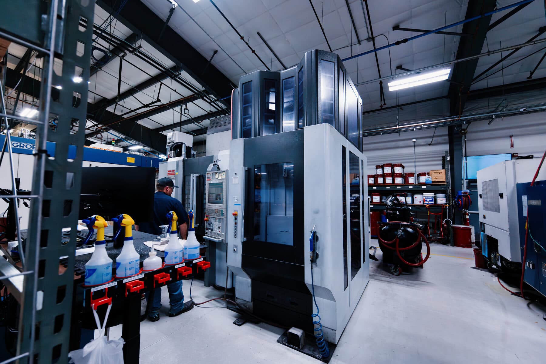 An operator beside a vertical machining centre on the shop floor